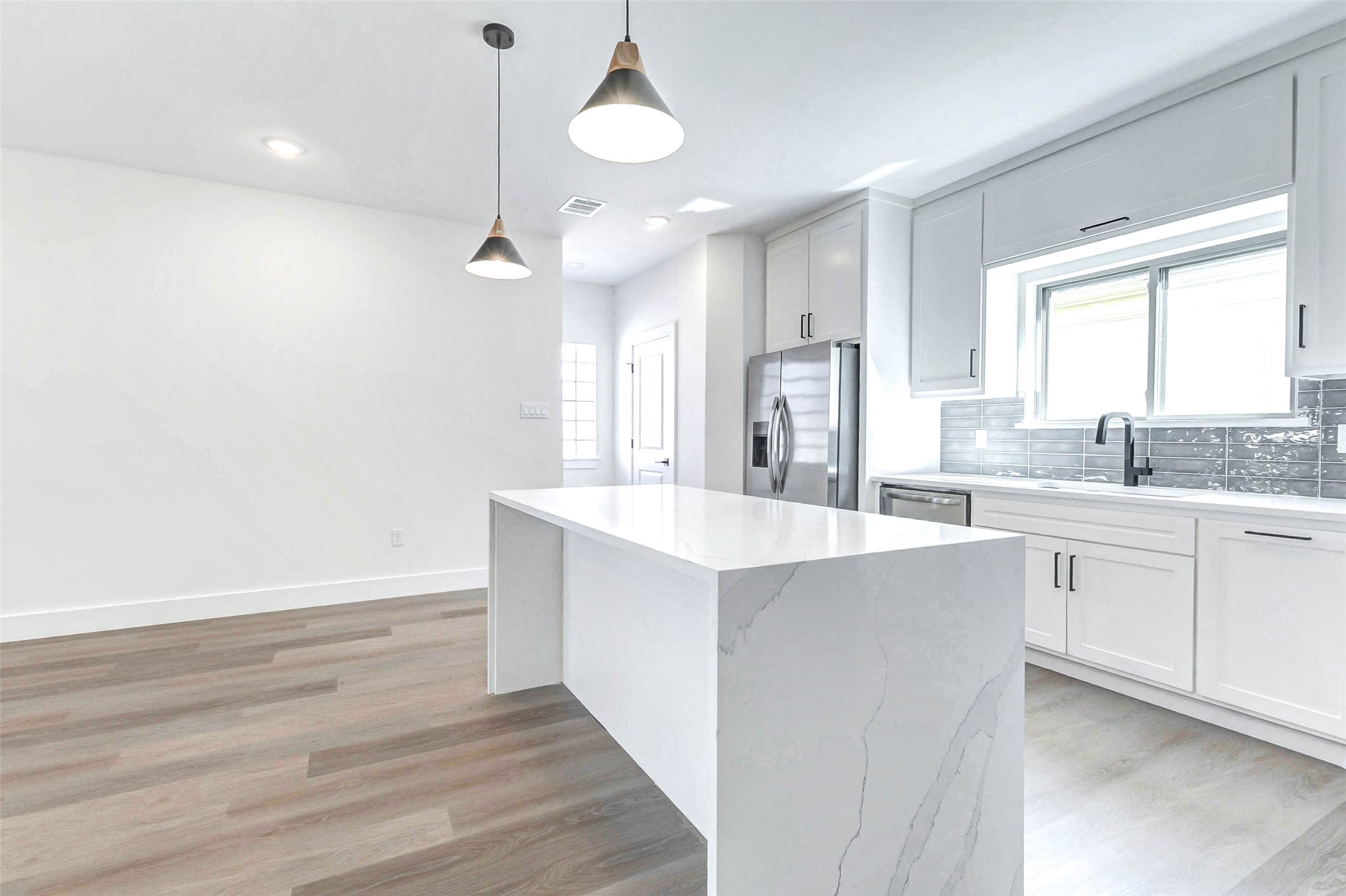 5638 Dolores Street Houston, TX 77057 - Photo 6 of 47 a large kitchen with cabinets wooden floor and a sink