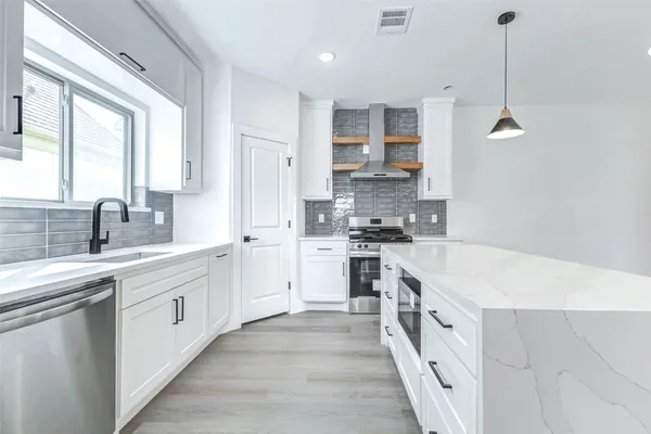 a large kitchen with stainless steel appliances kitchen island granite countertop a sink and cabinets