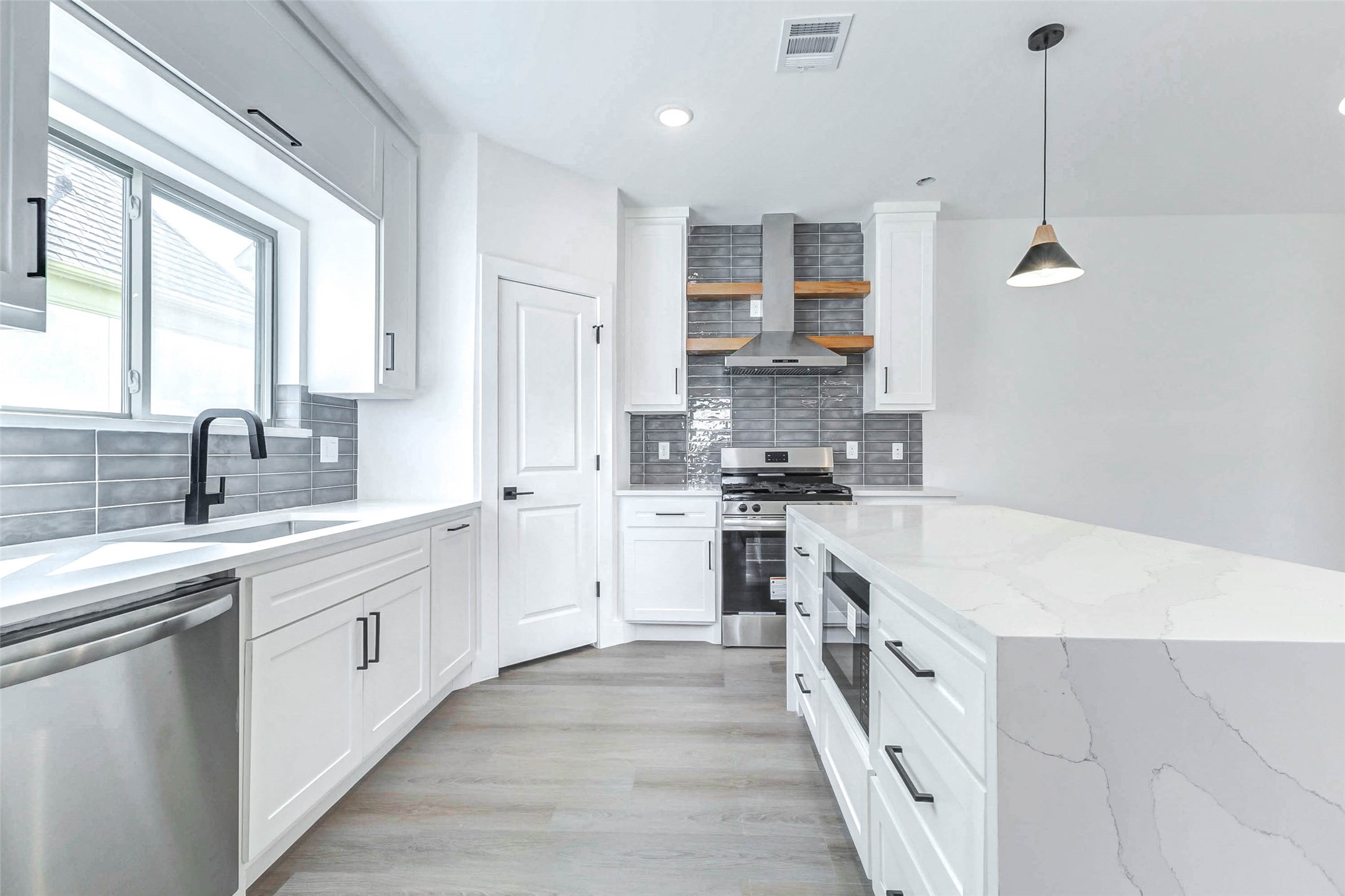 5638 Dolores Street Houston, TX 77057 - Photo 8 of 47 a large kitchen with stainless steel appliances kitchen island granite countertop a sink and cabinets