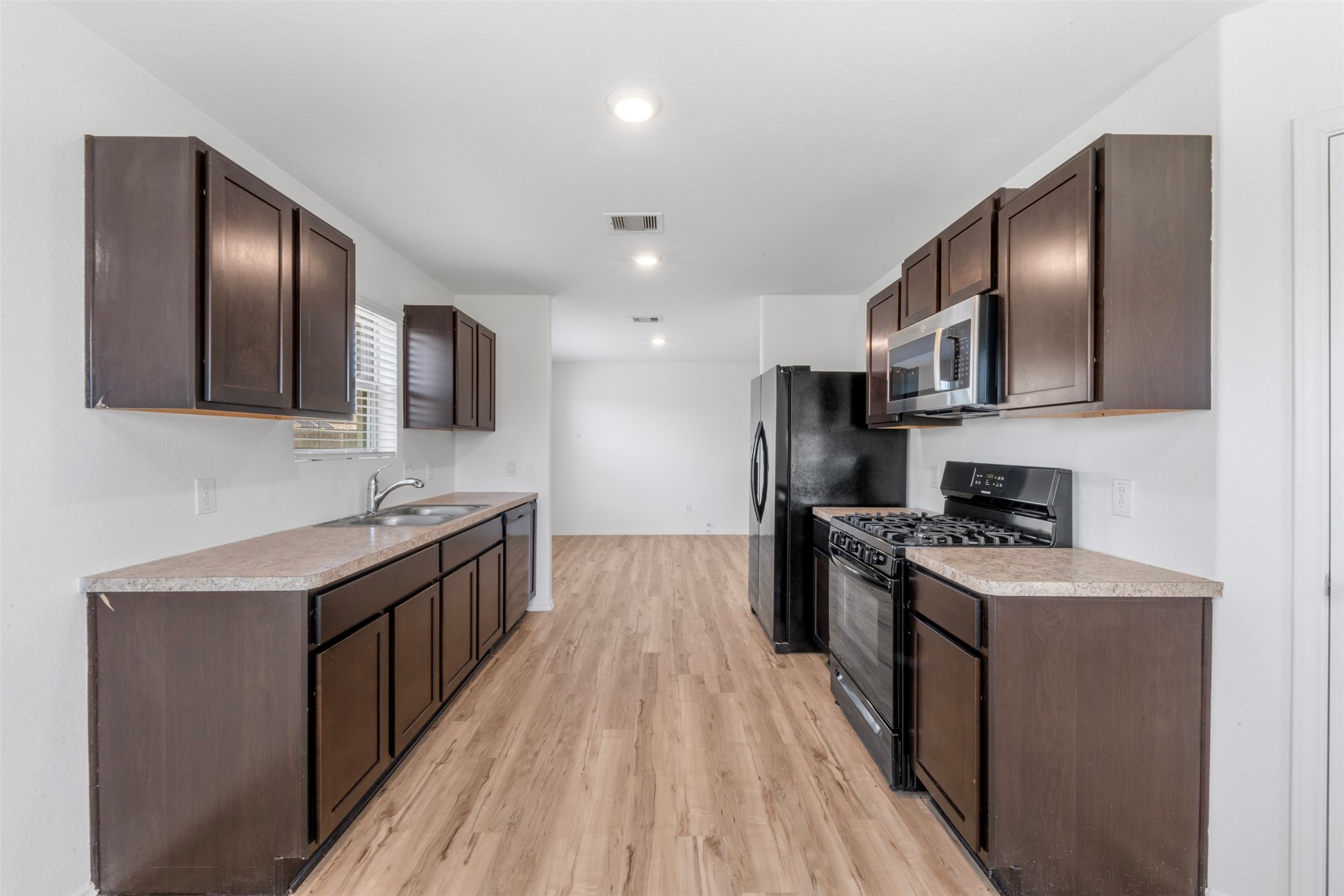 14602 Broadbury Pond Road Rosharon, TX 77583 - Photo 11 of 22 a kitchen with stainless steel appliances granite countertop a stove top oven a sink dishwasher a refrigerator and cabinets with wooden floor