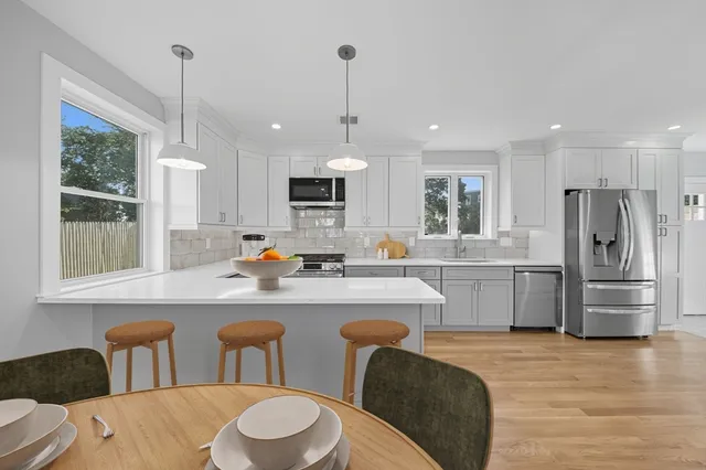 a kitchen with white cabinets and stainless steel appliances