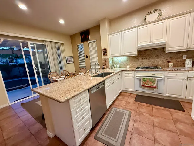 a kitchen with stainless steel appliances granite countertop a sink stove and cabinets