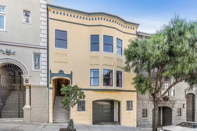 a front view of a building with a tree