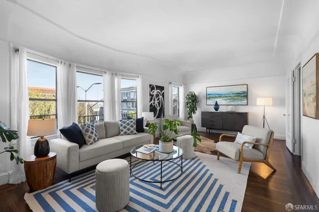 a dining room with furniture potted plants and wooden floor