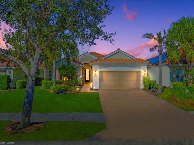 a front view of a house with a garden and yard