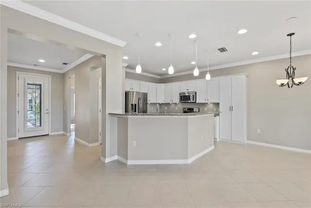 a view of kitchen with kitchen island and stainless steel appliances
