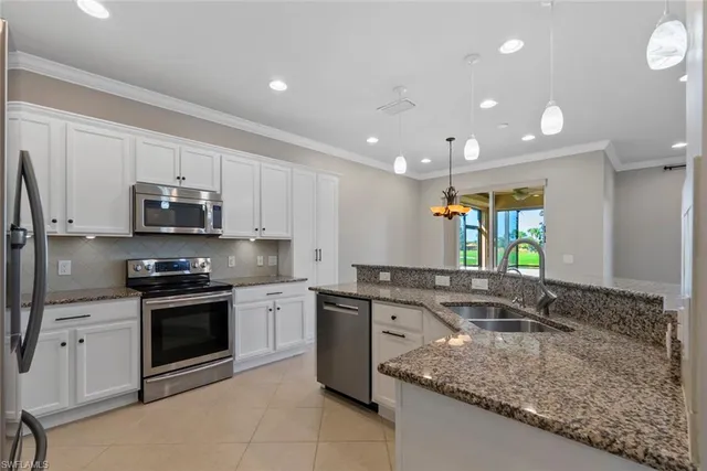 a kitchen with stainless steel appliances granite countertop a sink stove and cabinets