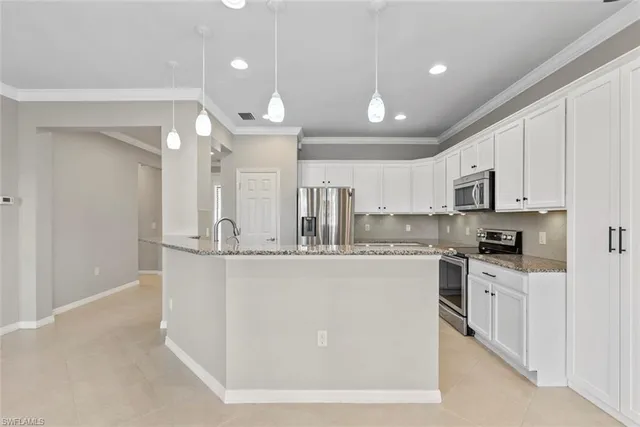 a kitchen with stainless steel appliances granite countertop a stove top oven a sink a refrigerator and white cabinets