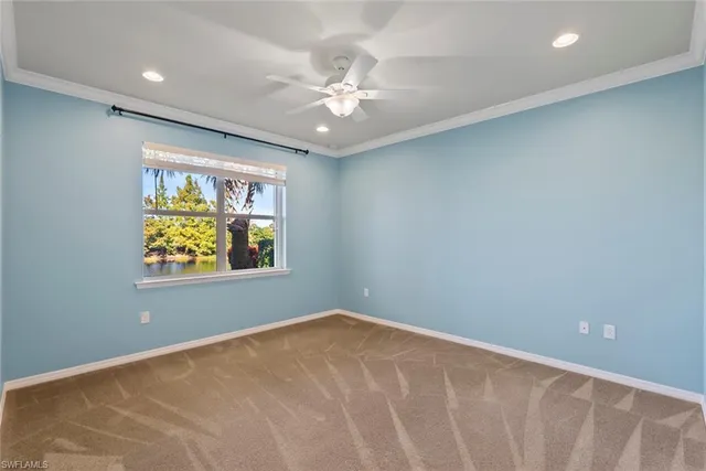 an empty room with windows and chandelier fan