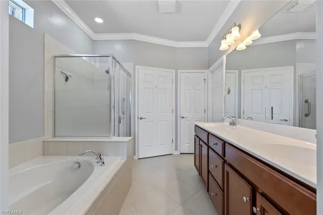 a bathroom with a tub a sink and a large mirror