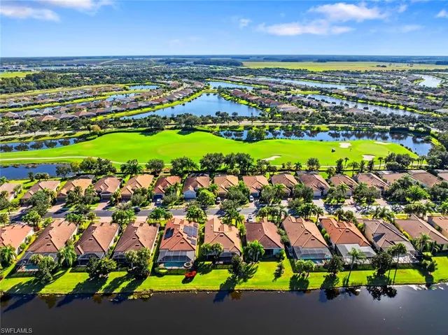 an aerial view of residential houses with outdoor space and trees