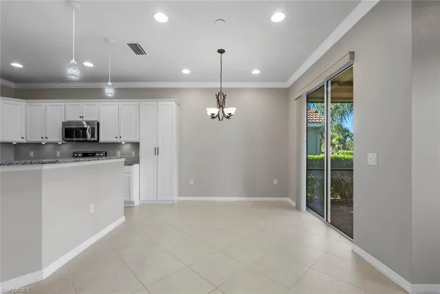 a view of a kitchen with a sink and dishwasher a refrigerator with white cabinets