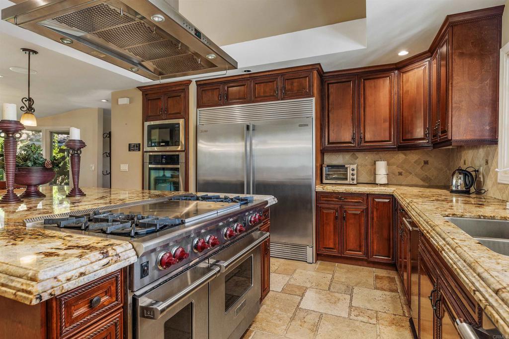 16346 Via Del Alba Rancho Santa Fe, CA 92067 - Photo 8 of 34 a kitchen with stainless steel appliances granite countertop a stove top oven a sink and dishwasher