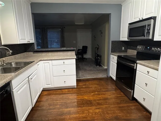 a kitchen with cabinets and wooden floor
