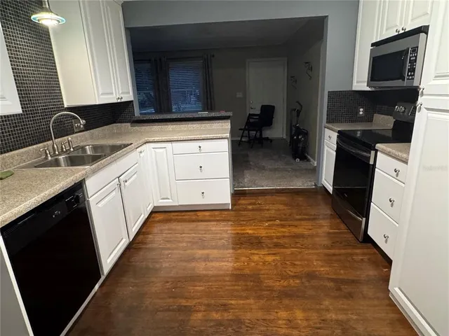 a large kitchen with stainless steel appliances a large counter top and a stove