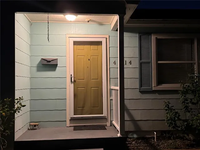 a view of a kitchen with refrigerator and wooden floor