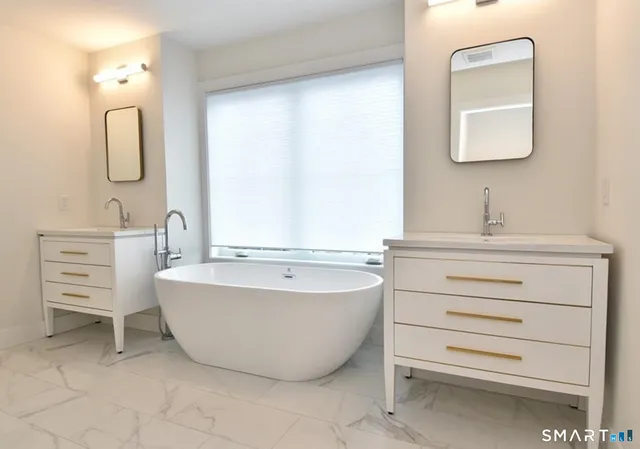 a bathroom with a bathtub sink and mirror