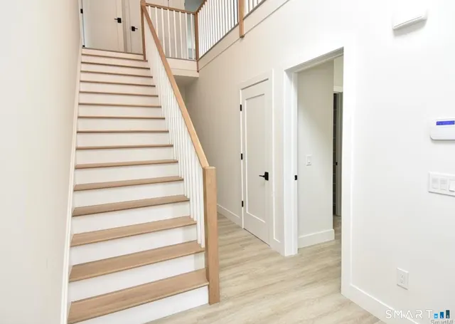 a view of a hallway with wooden floor and entryway
