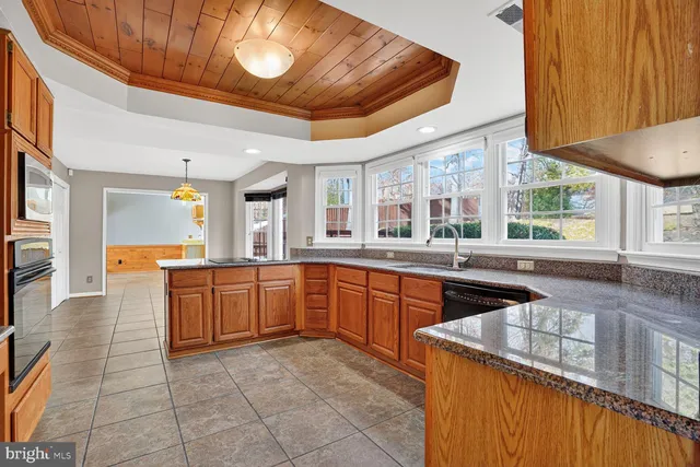 a large kitchen with stainless steel appliances granite countertop a stove and a sink