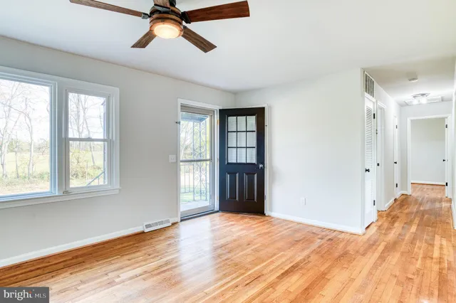 a view of empty room with wooden floor and window