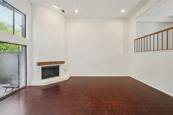 a view of an empty room with a fireplace and a window