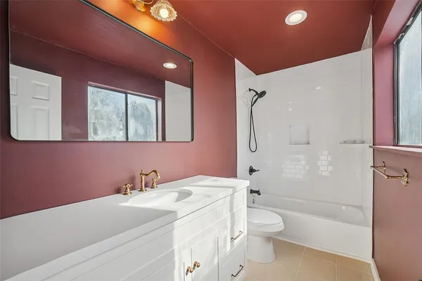 a bathroom with a granite countertop sink a toilet and shower