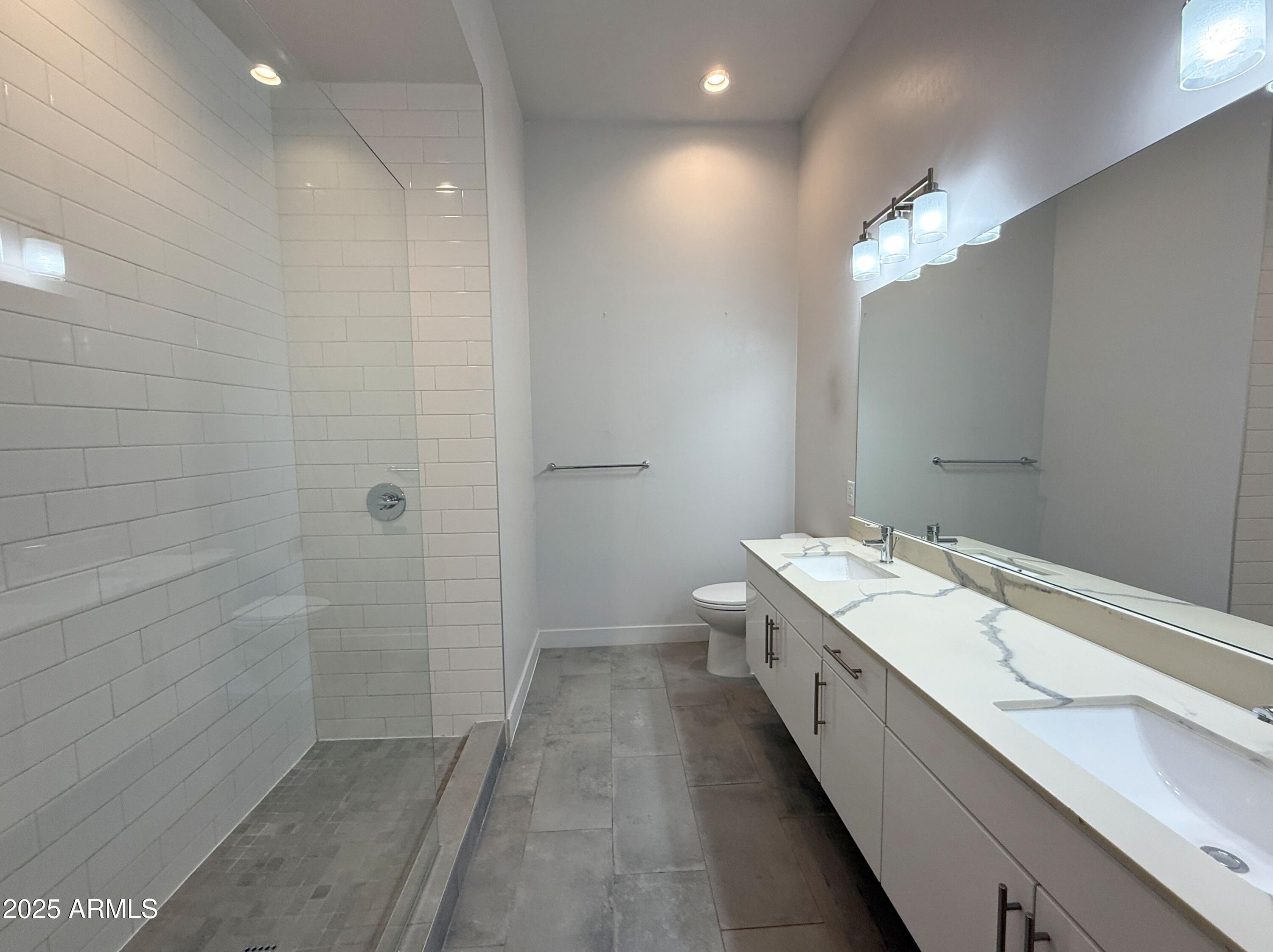 3131 North Central Avenue, Unit 7004 Phoenix, AZ 85012 - Photo 12 of 26 a bathroom with a double vanity sink and a mirror