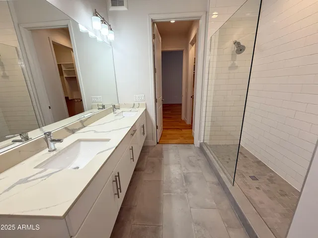 a spacious bathroom with a double vanity sink and a mirror