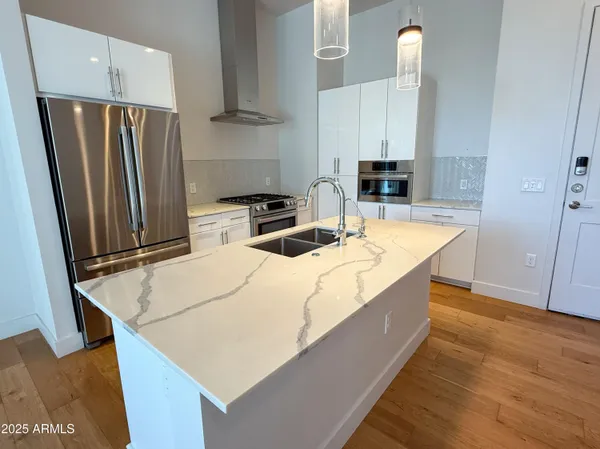 a kitchen with stainless steel appliances a refrigerator and a stove top oven