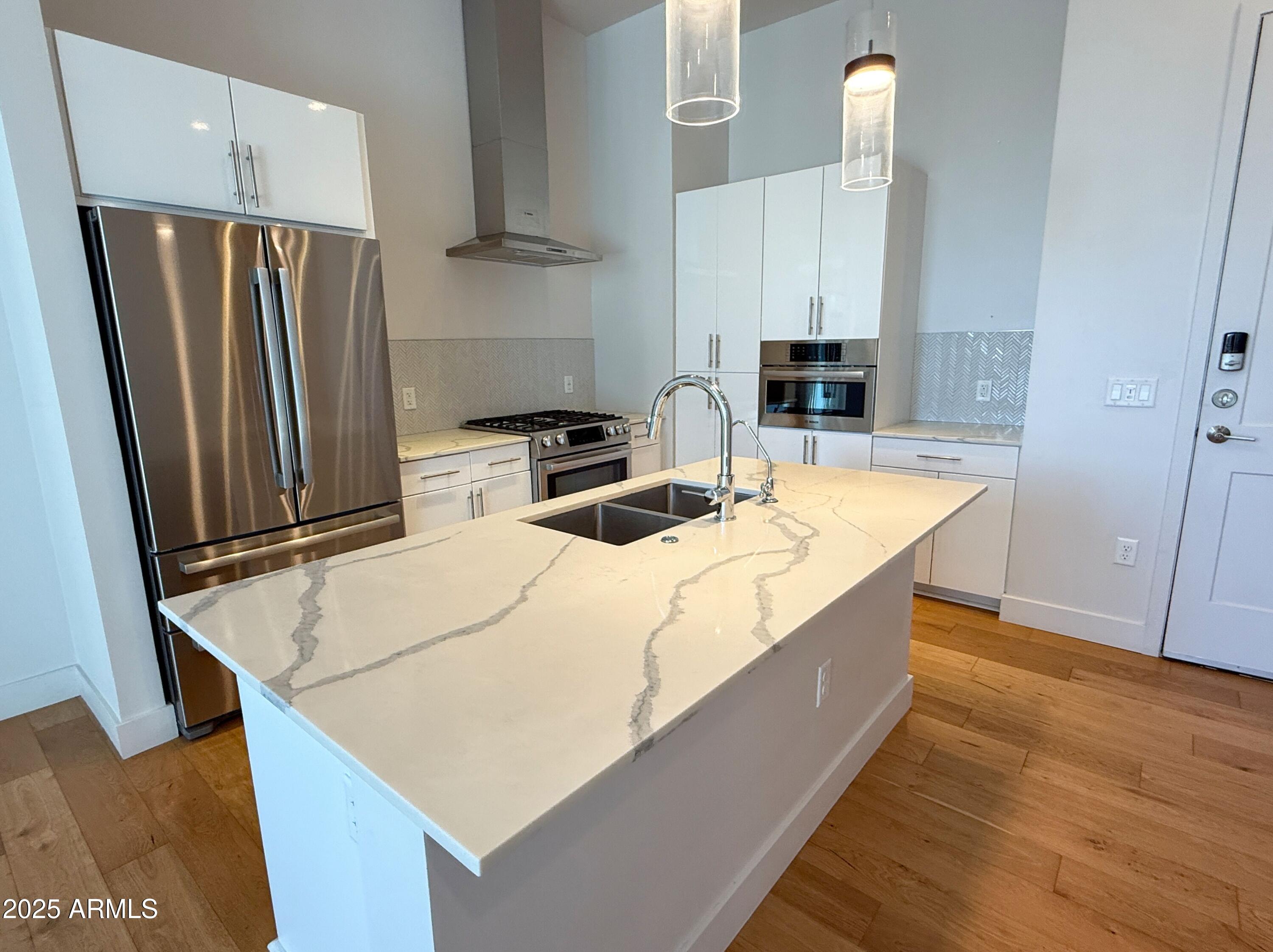 3131 North Central Avenue, Unit 7004 Phoenix, AZ 85012 - Photo 5 of 26 a kitchen with stainless steel appliances a refrigerator and a stove top oven