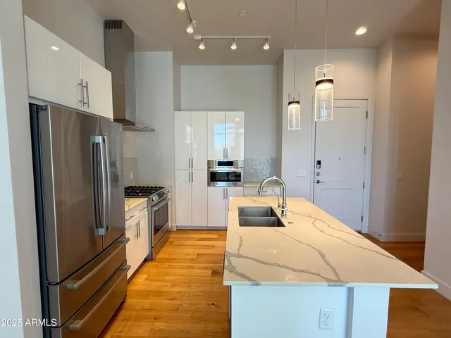 a kitchen with kitchen island a counter top space stainless steel appliances and cabinets