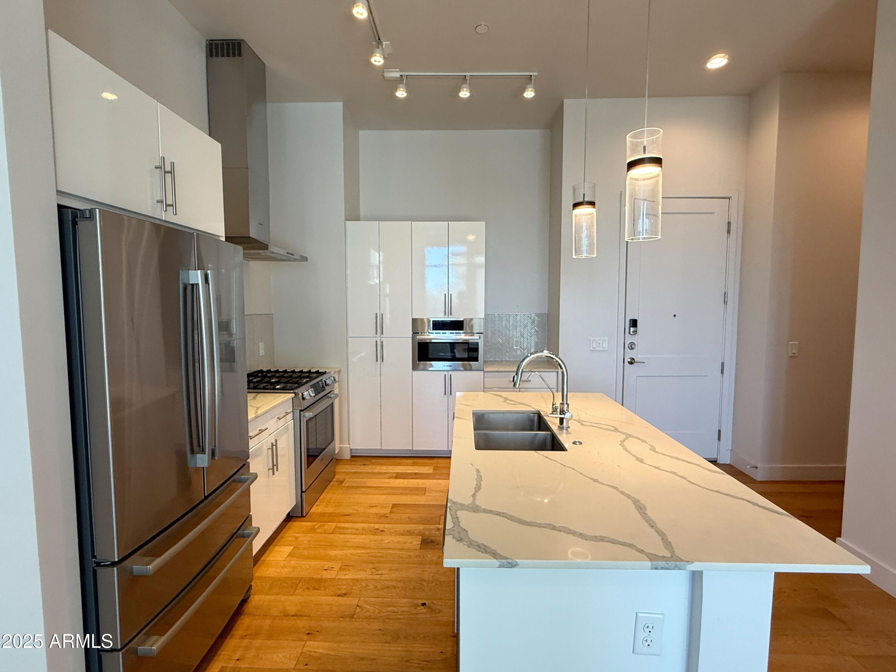 3131 North Central Avenue, Unit 7004 Phoenix, AZ 85012 - Photo 6 of 26 a kitchen with kitchen island a counter top space stainless steel appliances and cabinets