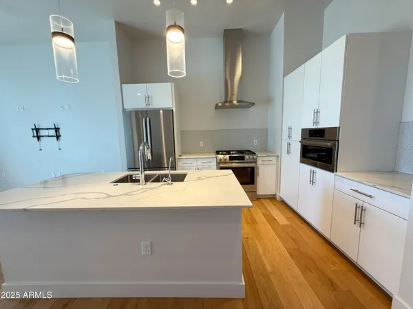 a kitchen with kitchen island sink stove and refrigerator