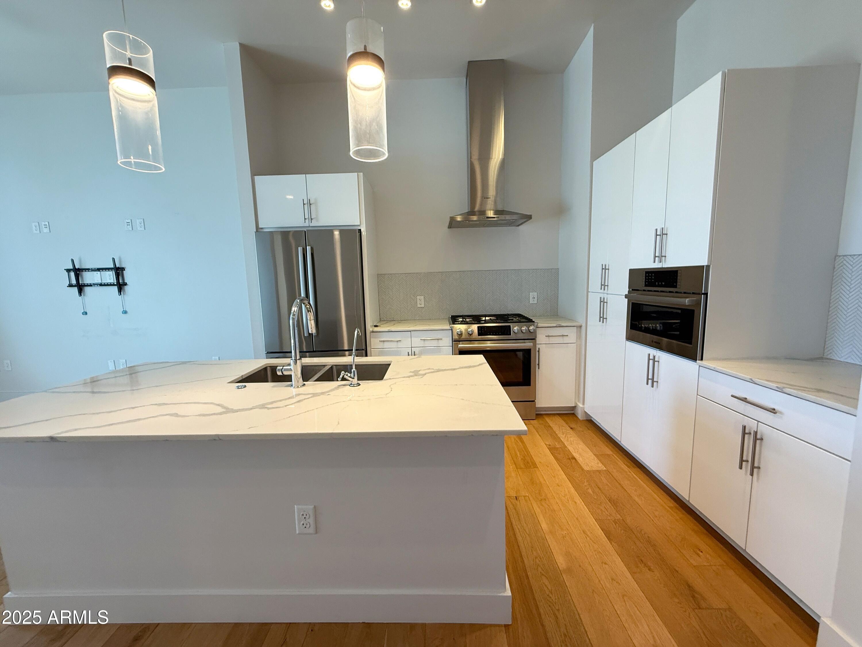 3131 North Central Avenue, Unit 7004 Phoenix, AZ 85012 - Photo 7 of 26 a kitchen with kitchen island sink stove and refrigerator