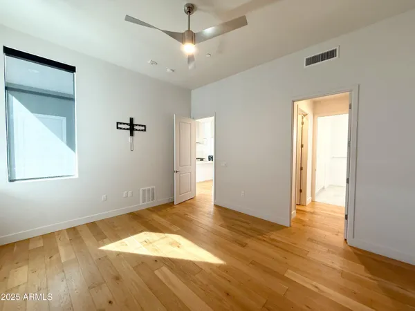 an empty room with wooden floor and windows