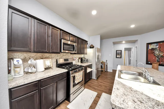 a large kitchen with granite countertop lots of counter top space sink and cabinets