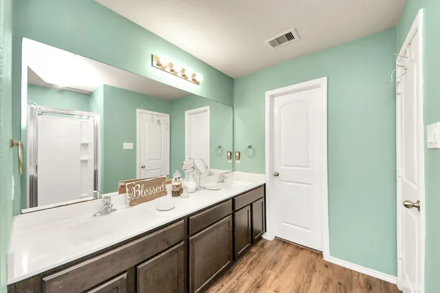 a spacious bathroom with a double vanity sink and a mirror