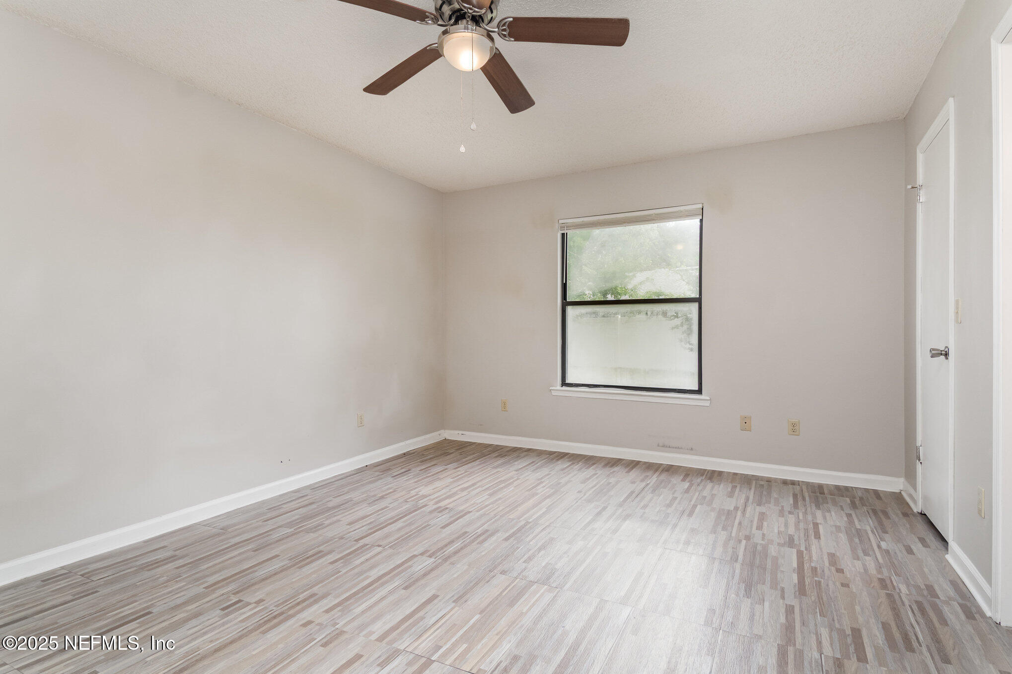 7945 Amandas Crossing Drive East Jacksonville, FL 32244 - Photo 4 of 15 wooden floor in an empty room with a window