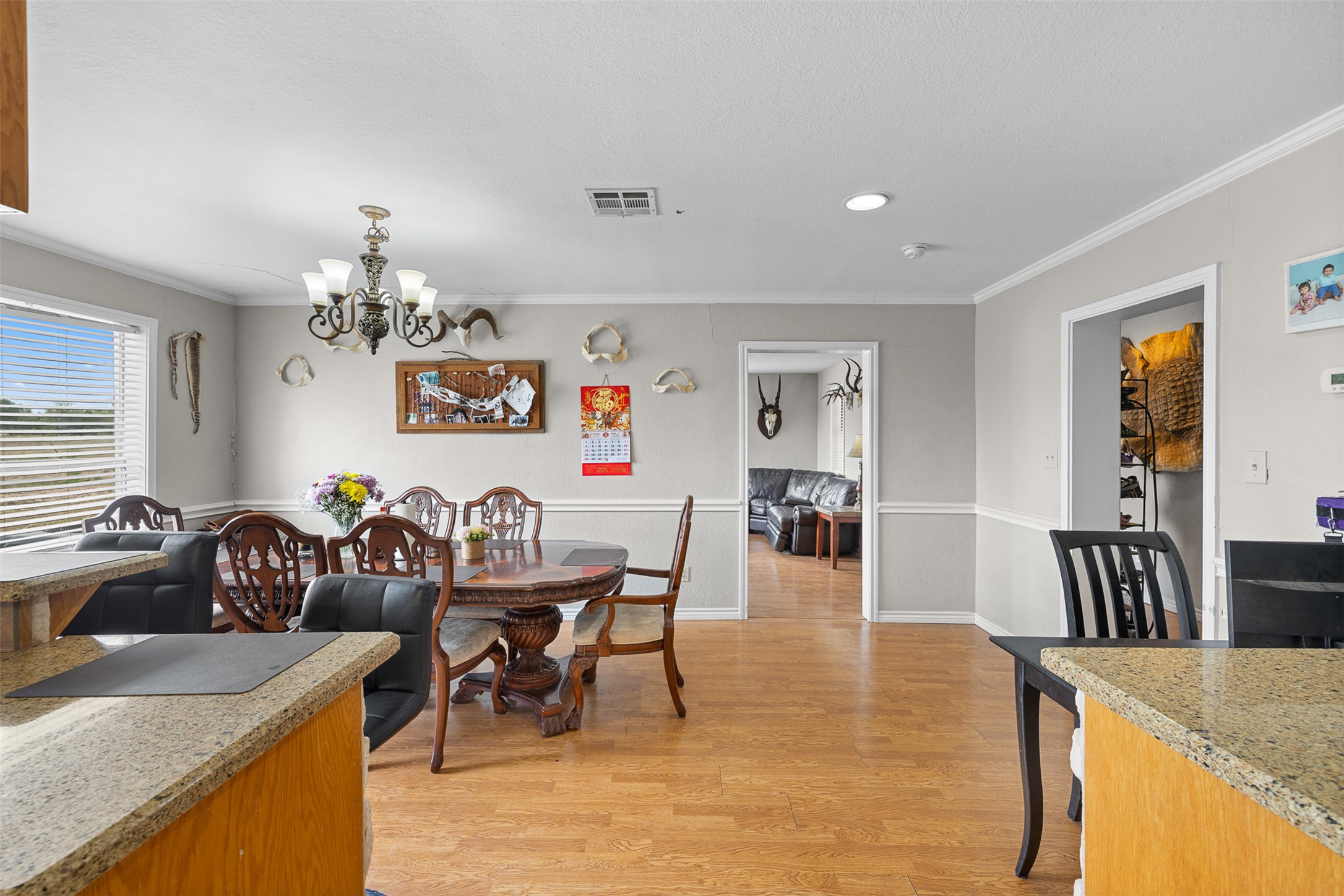 9765 State Park Road Lockhart, TX 78644 - Photo 25 of 40 a view of a dining room and livingroom with furniture wooden floor a rug a flat screen tv and a chandelier