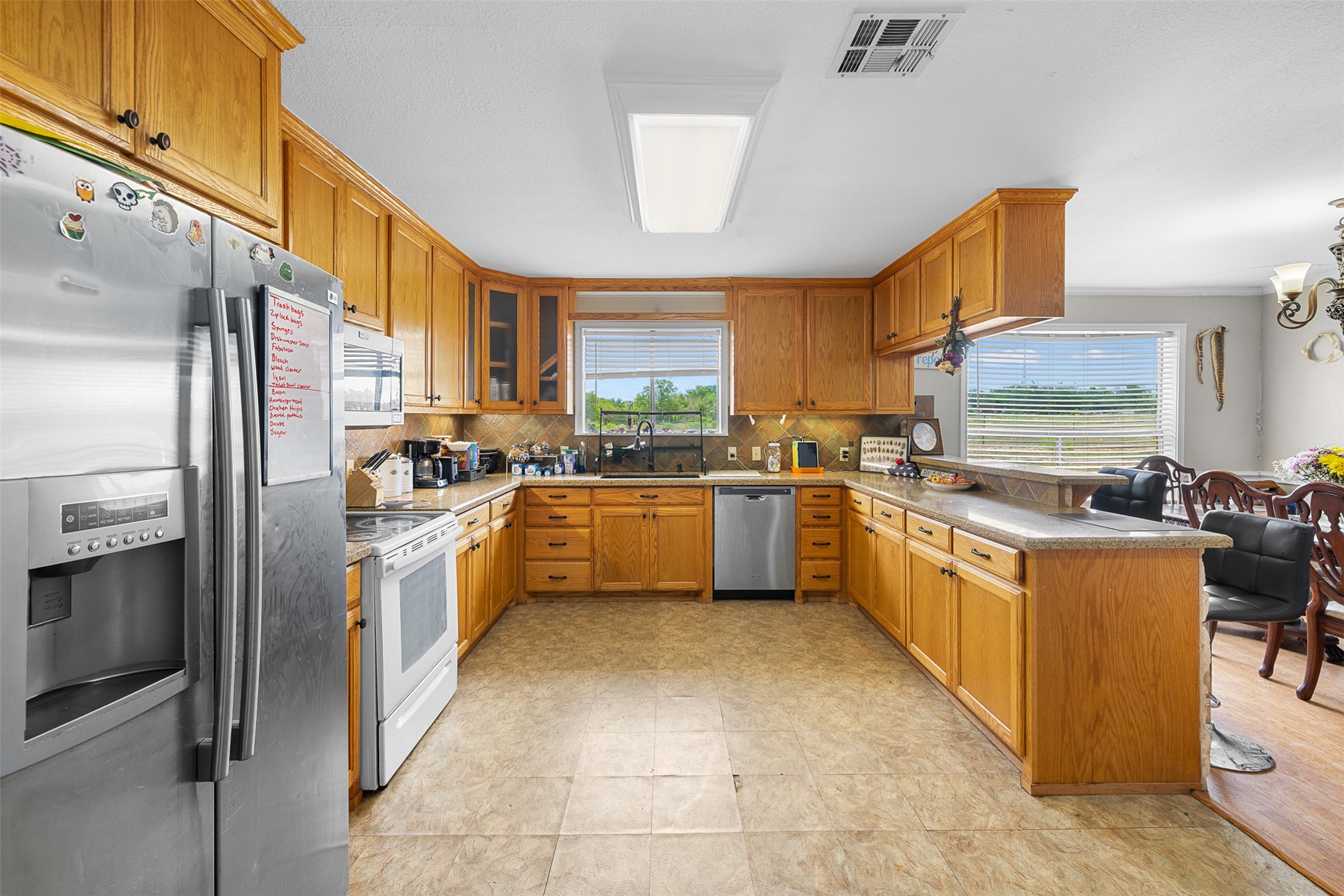 9765 State Park Road Lockhart, TX 78644 - Photo 26 of 40 a kitchen with stainless steel appliances granite countertop a sink counter space cabinets and a large window