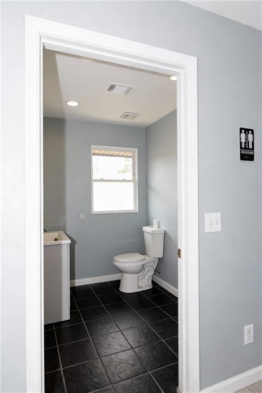 706 Collins Hill Road Lawrenceville, GA 30046 - Photo 16 of 33 a bathroom with a toilet sink and a mirror