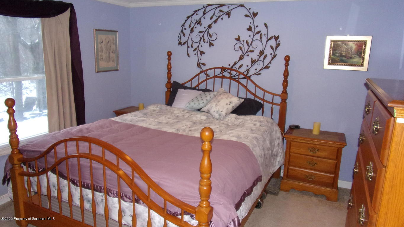 283 Bortree Road Moscow, PA 18444 - Photo 5 of 19 a bedroom with a bed and dresser with mirror