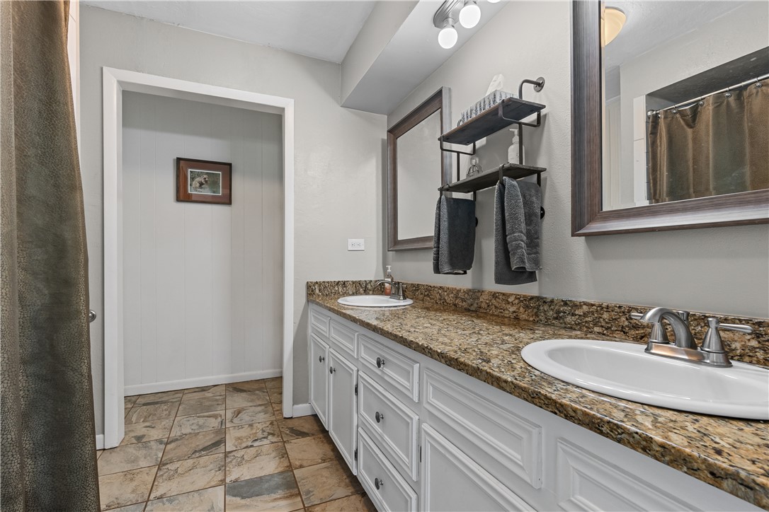 9269 Wheelock Hall Road Hearne, TX 77859 - Photo 15 of 25 a bathroom with a granite countertop sink a mirror and a shower