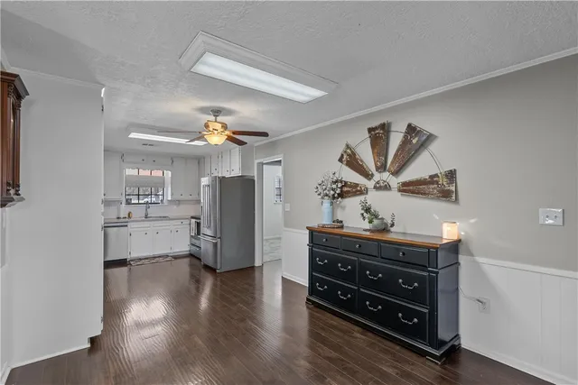 a kitchen with stainless steel appliances a refrigerator and a wooden floor