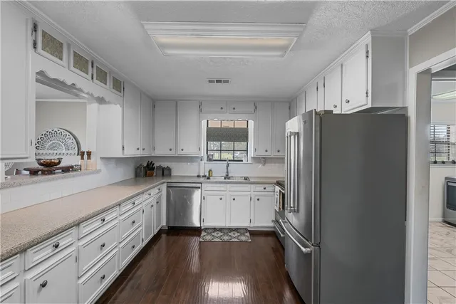 a kitchen with a refrigerator sink stove and cabinets
