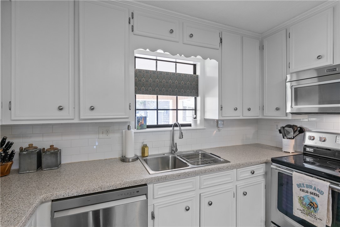 9269 Wheelock Hall Road Hearne, TX 77859 - Photo 9 of 25 a kitchen with stainless steel appliances granite countertop white cabinets a window and a sink