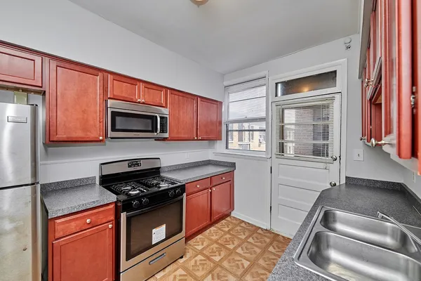 a kitchen with sink a microwave and cabinets