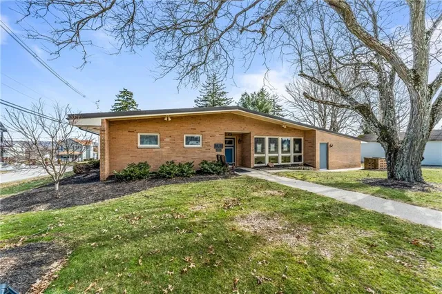 a view of a yard in front of a house with large trees