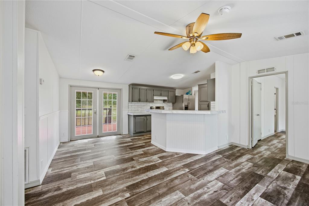 4950 80 Street Chiefland, FL 32626 - Photo 13 of 68 a view of a living room and kitchen with a ceiling fan