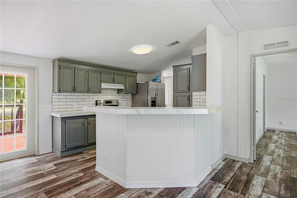 4950 80 Street Chiefland, FL 32626 - Photo 15 of 68 a kitchen with a refrigerator and a stove top oven